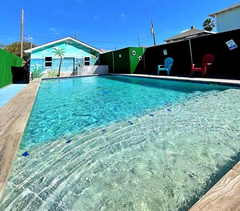 a large swimming pool with clear blue water at The Poolside Bungalow in Galveston