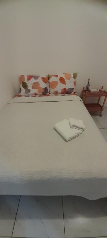 ein weißes Bett mit zwei Kissen darüber in der Unterkunft Casa em João Pessoa Paraíba in João Pessoa