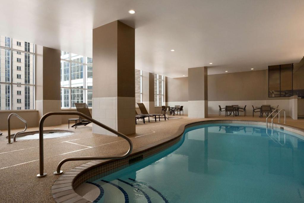 una piscina en un hotel con sillas y mesas en Hyatt Place Minneapolis/Downtown en Minneápolis