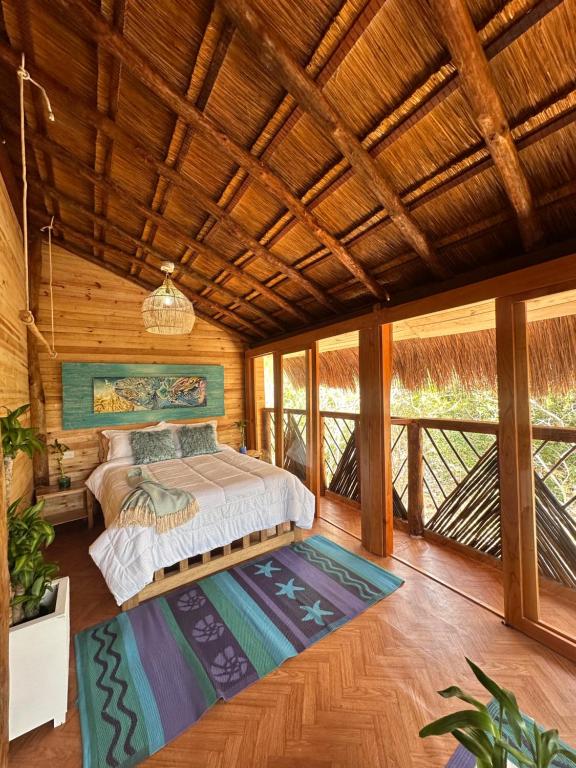 ein Schlafzimmer mit einem Bett in einem Zimmer mit Holzdecken in der Unterkunft Cristal Blue Barú in Barú