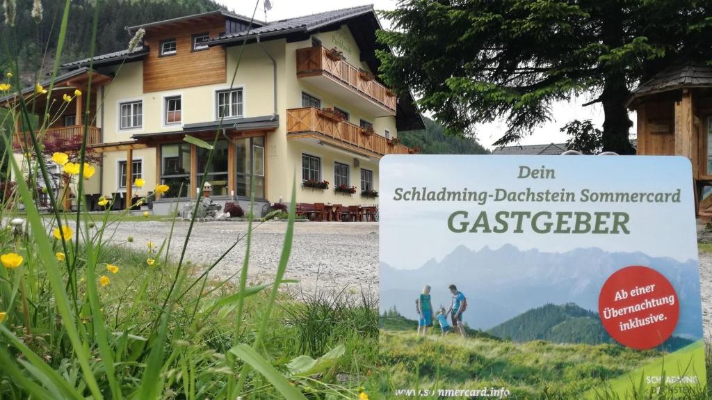 een bord in het gras voor een huis bij Familien & Wander-Pension Purkhardt in Donnersbachwald