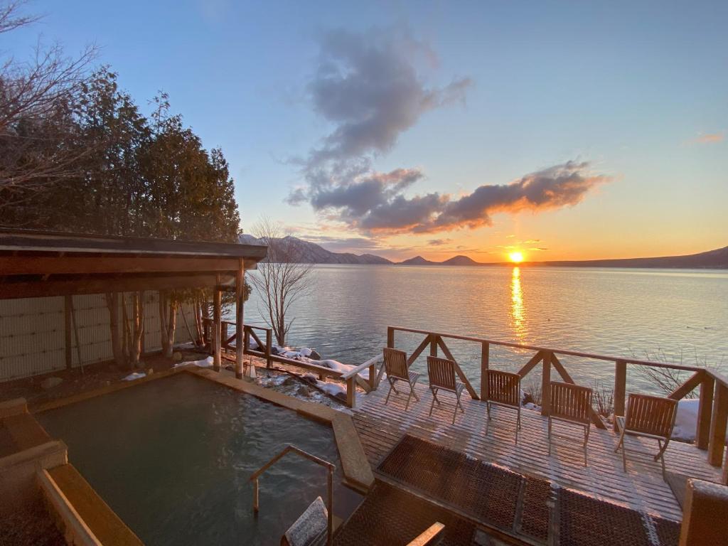 una casa con piscina sulla riva di un lago di Marukoma Onsen Ryokan a Chitose