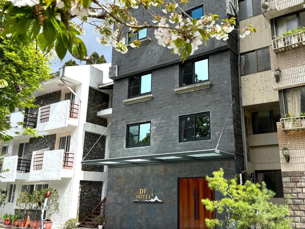 un edificio de apartamentos con una fachada gris y una puerta en Dafong Hotel en Zhongzheng