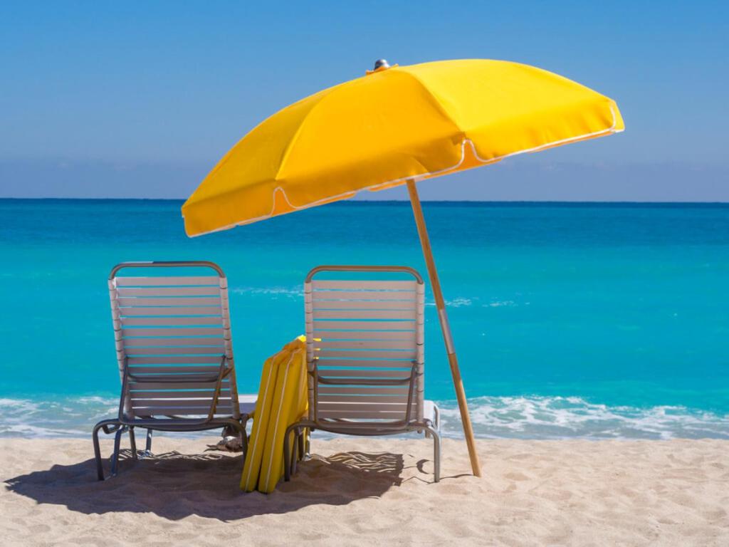 zwei Stühle unter einem Sonnenschirm am Strand in der Unterkunft LAS PERLAS - 1º Linea in Denia