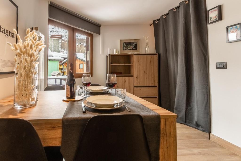 une salle à manger avec une table en bois et des verres à vin dans l'établissement HelloChalet - Friends Ski House, à Breuil-Cervinia