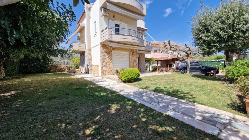 uma casa com um quintal em frente em Βίλα Χαρά em Eretria