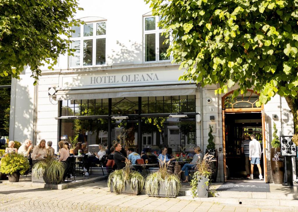 a group of people sitting at tables outside of a restaurant at Hotel Oleana in Bergen