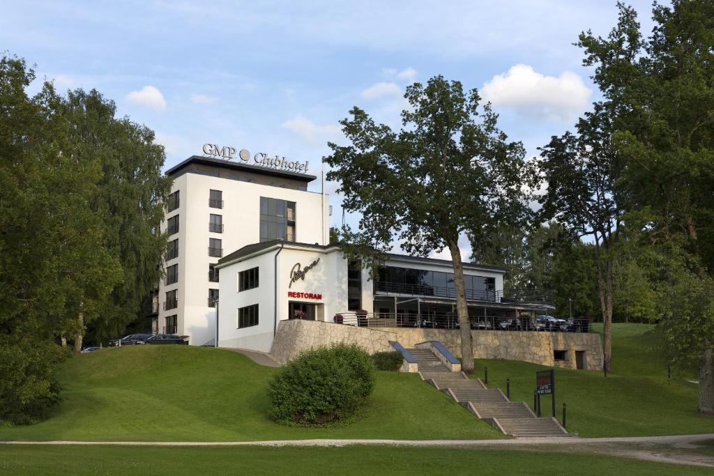 Un bâtiment blanc avec un panneau en haut dans l'établissement GMP Clubhotel Apartments, à Otepää