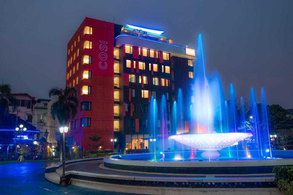 un hotel con una fuente frente a un edificio en COSI Vientiane Nam Phu en Vientián