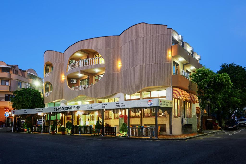 un gran edificio en una calle de la ciudad por la noche en Hotel Manz 2, en Pomorie