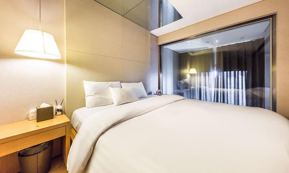 Un dormitorio con una gran cama blanca y una ventana en Yeongdeungpo Lifestyle F Hotel en Seúl