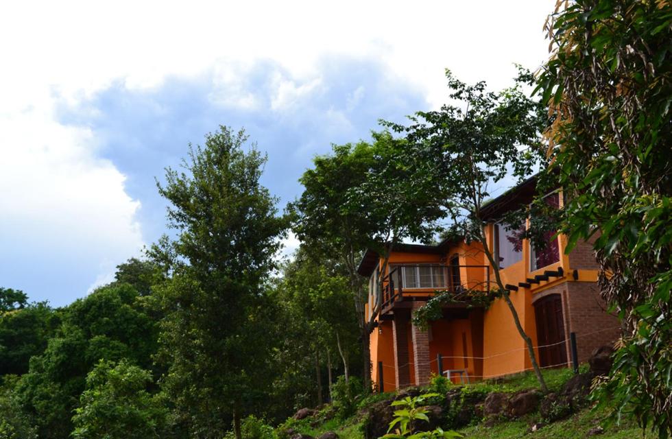 une maison orange sur une colline avec des arbres dans l'établissement Amaraka Lodge, à Leandro N. Alem