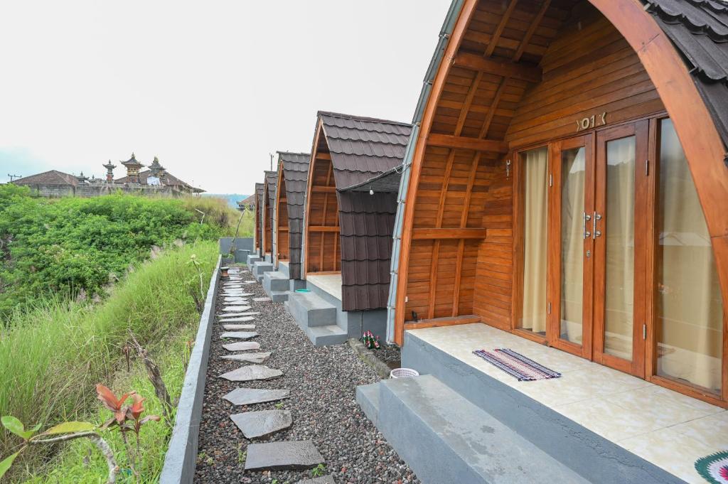 Une rangée de maisons en bois sur le côté d'une colline dans l'établissement Volcano Cabin Batur RedPartner, à Baturaja