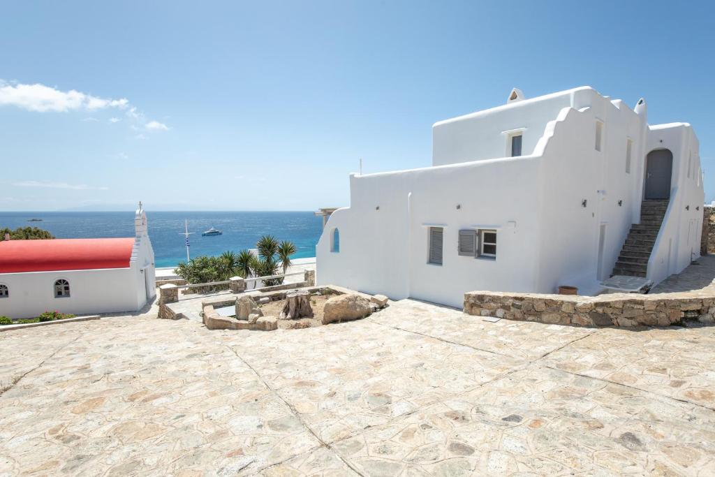 - un bâtiment blanc sur la plage avec l'océan en arrière-plan dans l'établissement Blue Moon Mykonos Homes, à Mykonos