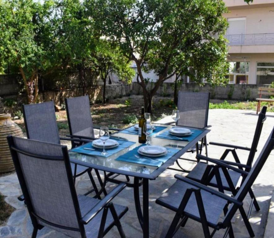 - une table bleue avec des chaises et une bouteille de vin dans l'établissement Betty's Garden House, à Nea Anchialos