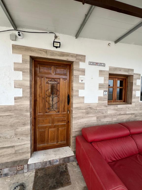 a room with a red couch and a wooden door at Casa Paula in Ceuta