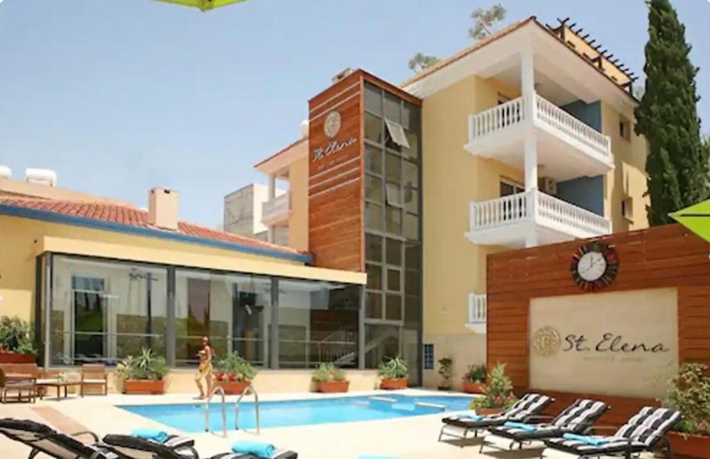 un hotel con piscina frente a un edificio en St Elena Boutique Residence en Lárnaca