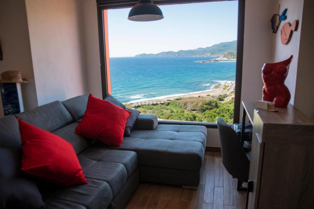 sala de estar con sofá y vistas al océano en DOMO A MARE en Magomadas