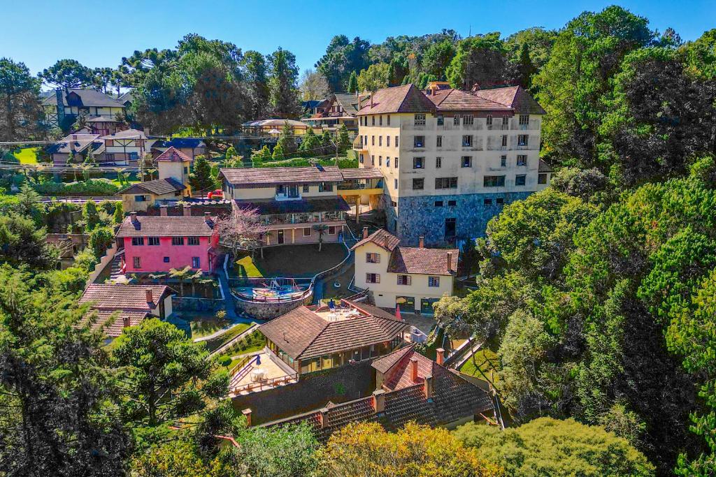 un grupo de casas en una colina con un edificio en VELINN Hotel Ninho do Falcão, en Monte Verde