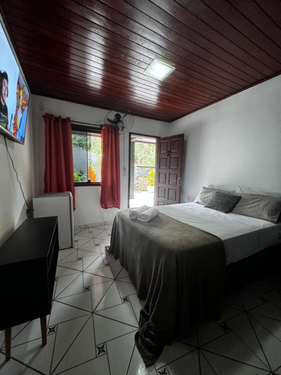 1 dormitorio con 1 cama con techo de madera en BLUE DOOR BRASIL en Ilha Grande