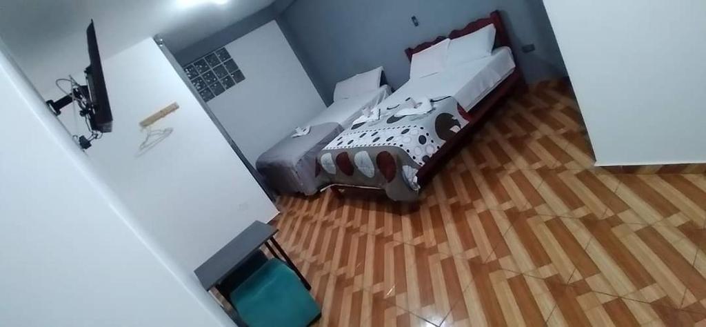 1 dormitorio con 1 cama y suelo de madera en Tumalki rooms en Trujillo