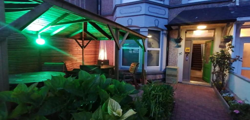 a house with a patio with a green lights at Morwenna Luxury Holiday Apartments in Llandudno