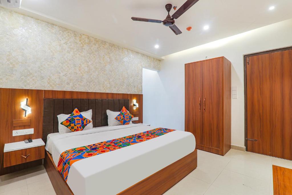 a bedroom with a large bed and a brown cabinet at FabHotel Raj Palace in Lucknow