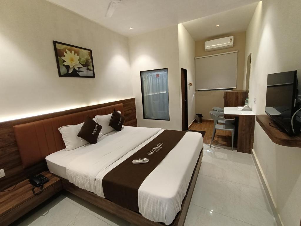 1 dormitorio con 1 cama grande y TV en Moon Lite Residency - Malad West, en Bombay