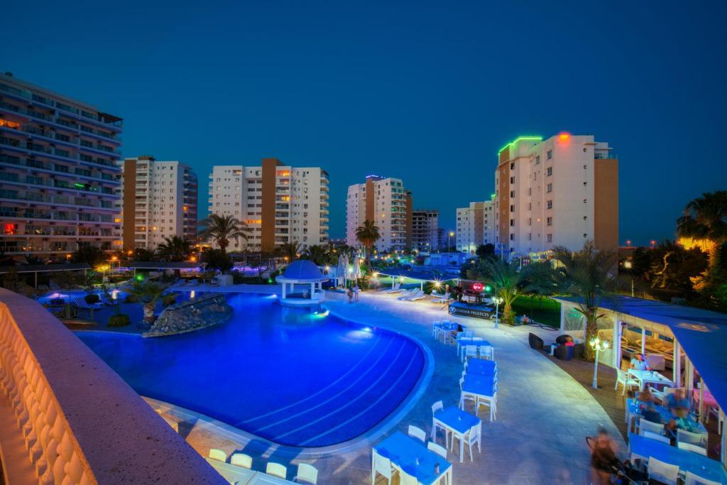 - une piscine en ville la nuit dans l'établissement Caesar Resort - Studio Apartments, à Iskele