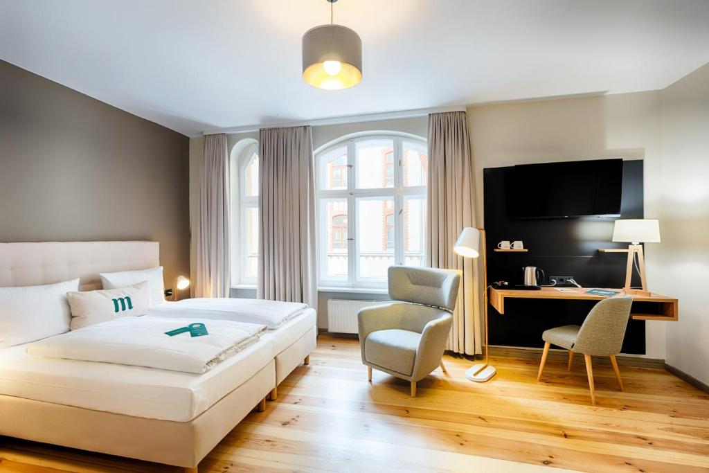 Cette chambre comprend un lit, un bureau et une télévision. dans l'établissement martas Hotel Berlin-Mitte, à Berlin