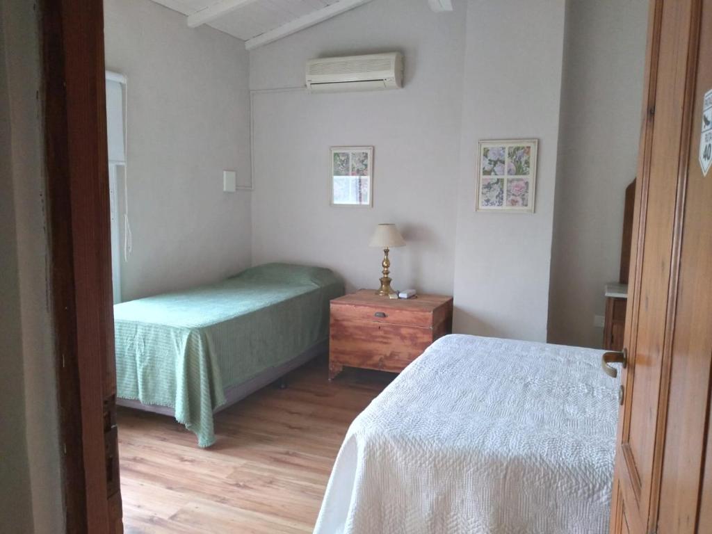 a bedroom with two beds and a wooden floor at El Olivo in Gualeguaychú