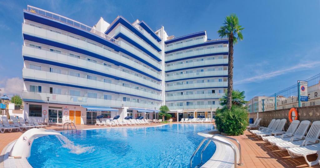 un hotel con piscina frente a un edificio en Hotel Mar Blau en Calella