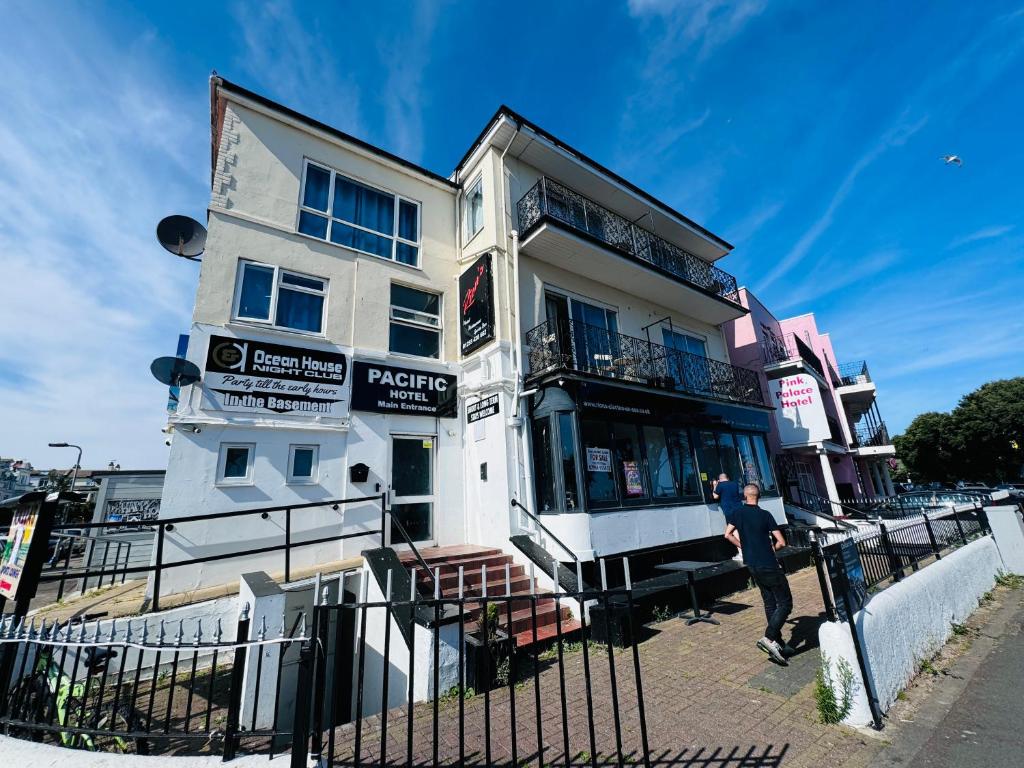 un homme debout devant un bâtiment blanc dans l'établissement Pacific Hotel, à Clacton-on-Sea