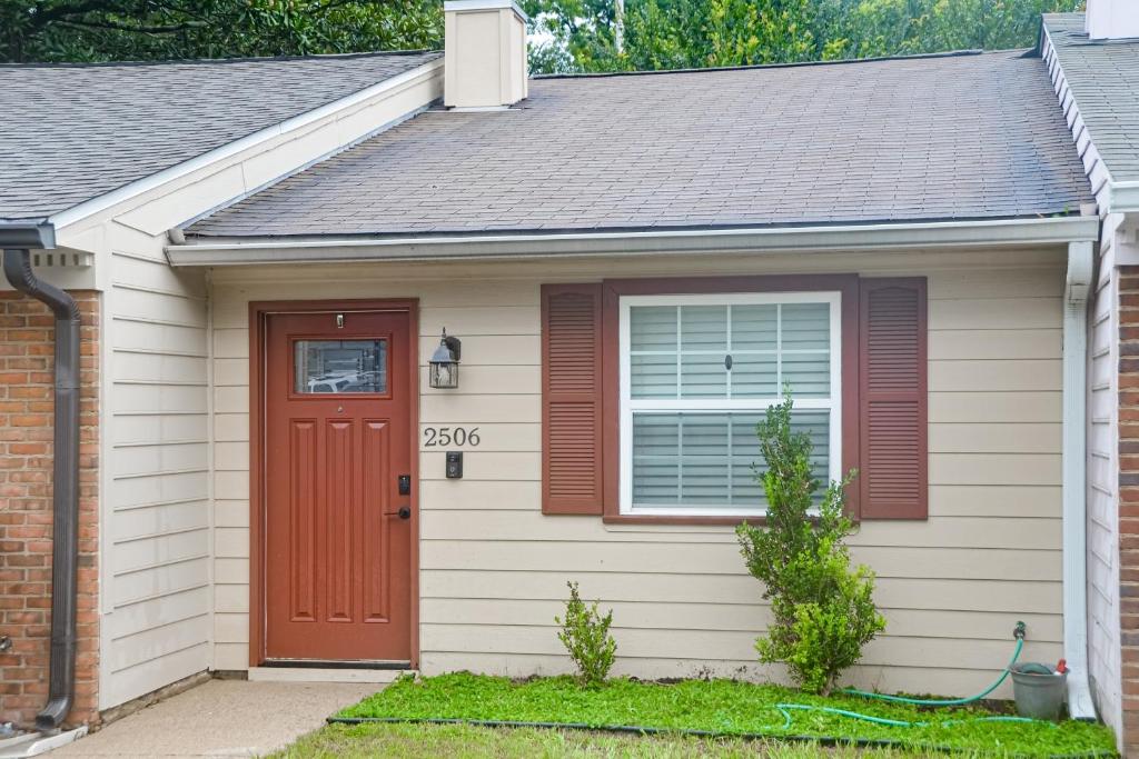 una pequeña casa con una puerta roja en Casa Mar en Tallahassee