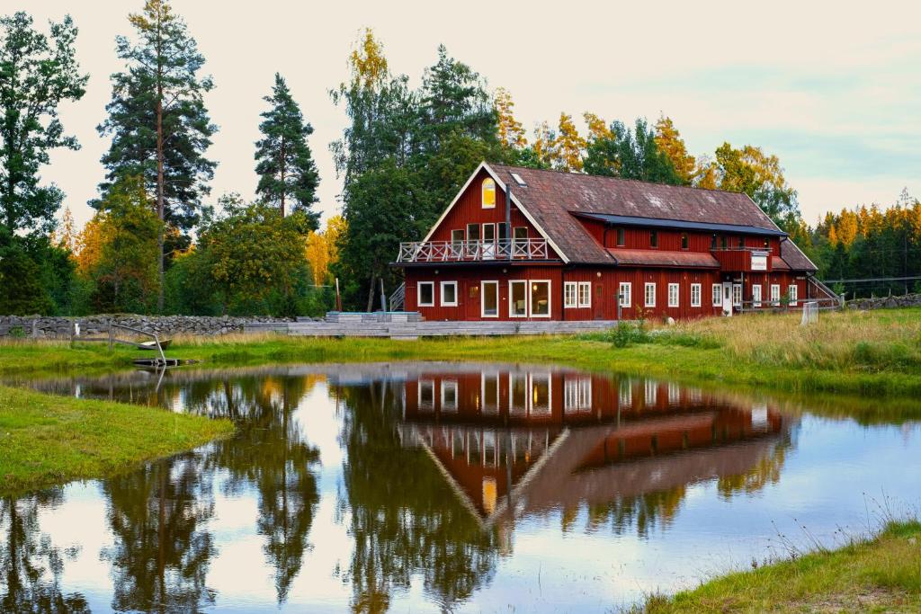 a red barn with a pond in front of it at Mundekulla in Mundekulla