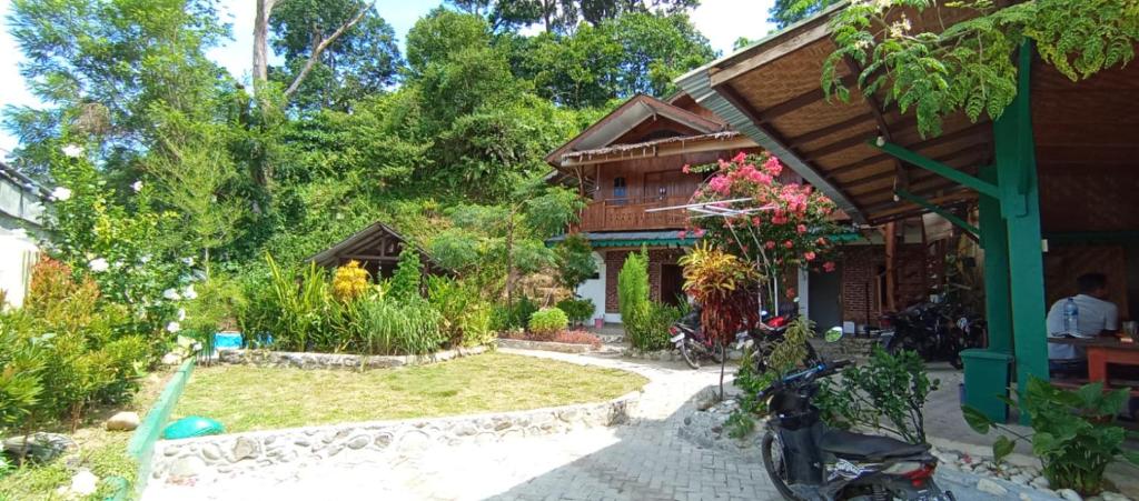 una casa con una motocicleta estacionada frente a ella en Monkey Business Tours and Accommodation en Bukit Lawang