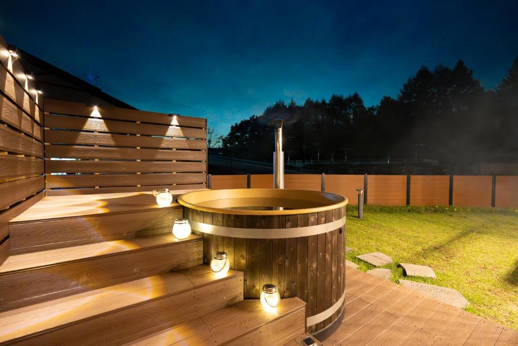 een houten terras met een hot tub met verlichting bij 르꼼떼블루 in Pyeongchang 