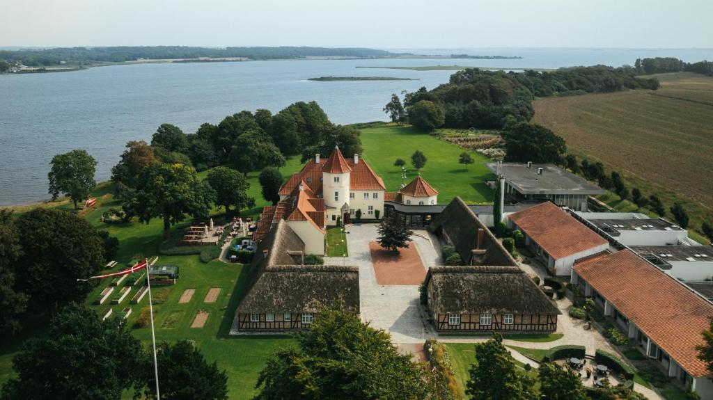 una vista aérea de una casa a orillas de un lago en Gl. Avernæs Sinatur Hotel & Konference en Ebberup