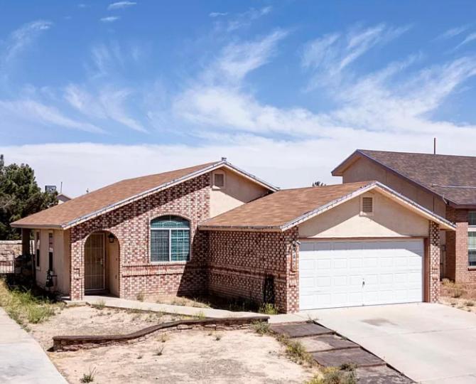 een stenen huis met een witte garage bij Rockclimbers house in El Paso