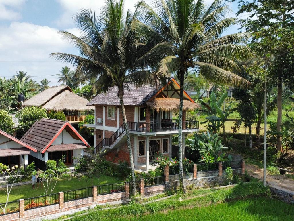 uma casa com palmeiras em frente em Novia Guest House Lombok-Tetebatu em Tetebatu