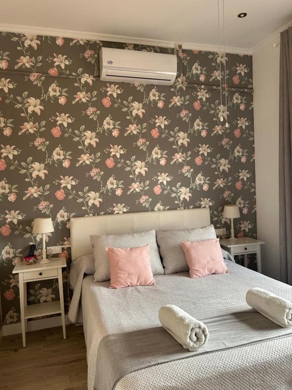 a bedroom with a bed with pink flowers on a wall at El Hidalgo in Almagro