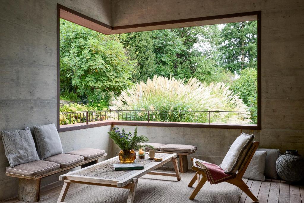 une terrasse couverte avec une table et des chaises ainsi qu'une grande fenêtre dans l'établissement Relais Castello di Morcote, à Morcote