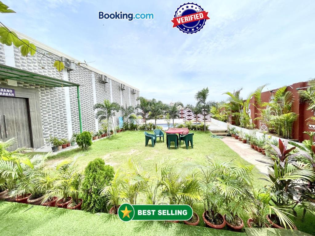 a garden with a table and chairs in it at HOTEL G RESORT ! PURI Swimming-pool-and-Garden, near-sea-beach-and-temple fully-air-conditioned-hotel with-lift-and parking-facility, Breakfast included, best hotel in puri - 2 in Puri