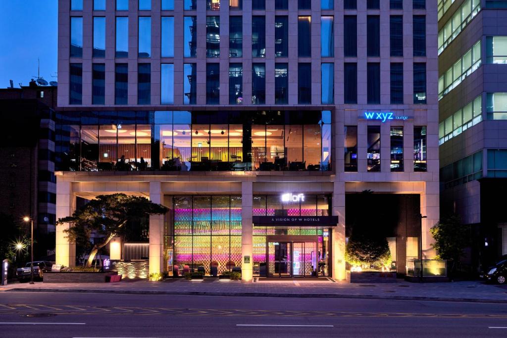 un gran edificio con muchas ventanas por la noche en Aloft Seoul Gangnam en Seúl