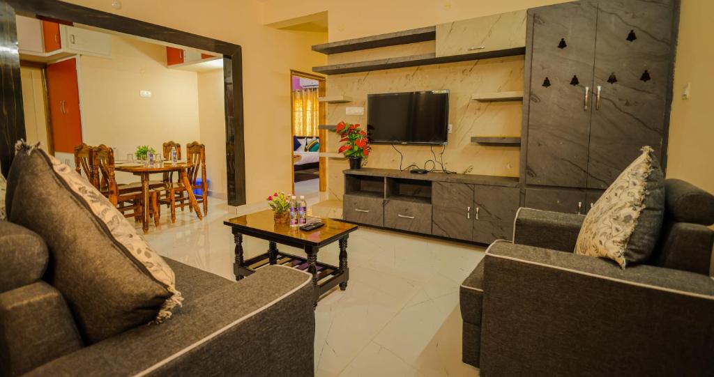 Sala de estar con 2 sofás y mesa en S V IDEAL HOMESTAY -2BHK SERVICE APARTMENTS-AC Bedrooms, Premium Amities, 2KM to Tiruchanoor Padmavathi Temple , 6KM to Alipiri, 24 HOURS Service BOYS Available, en Tirupati