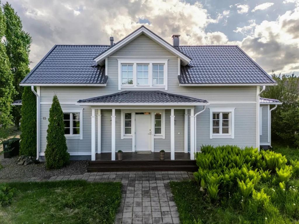 uma casa branca com um telhado azul em The Grey House em Kokkola