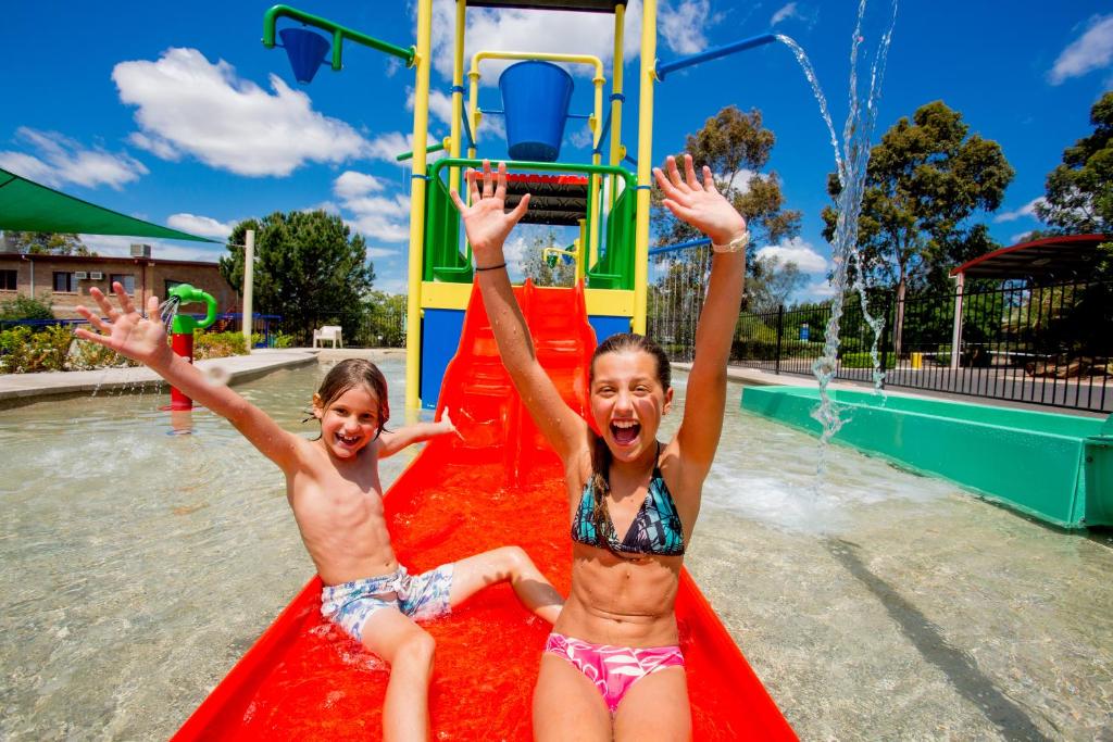 Due ragazze che giocano su uno scivolo in piscina di Discovery Parks - Dubbo a Dubbo