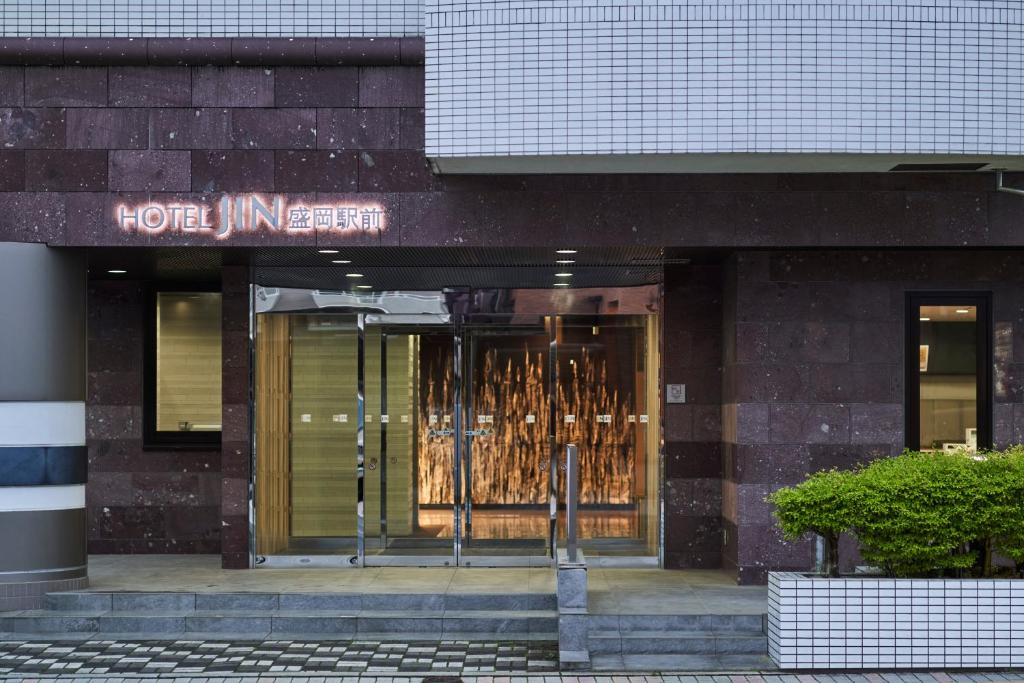 una tienda frente a un edificio con un cartel. en Hotel JIN Morioka Ekimae en Morioka