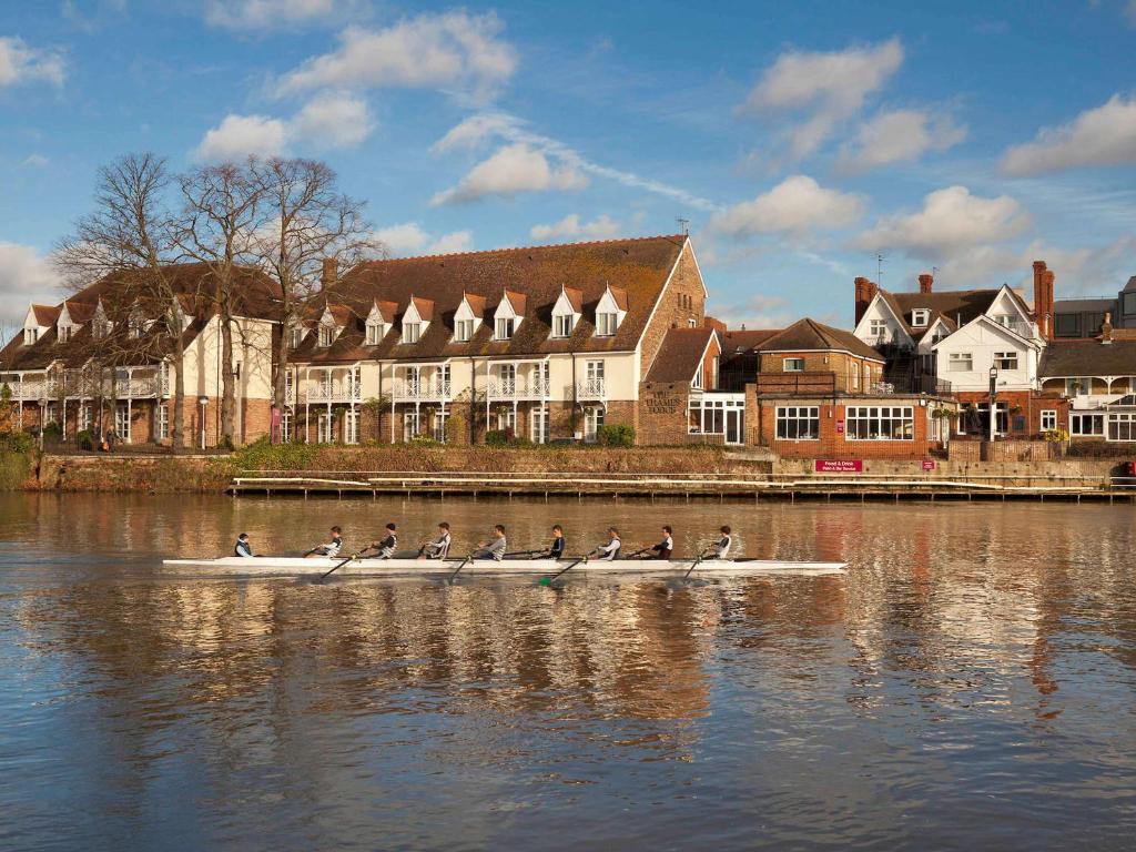 Un gruppo di persone in una barca sull'acqua di Mercure London Staines-upon-Thames Hotel a Staines