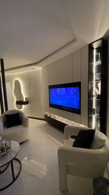 sala de estar con muebles blancos y TV de pantalla plana en Modern studio Self entry en Riad